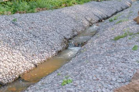 A stream with banks of gabion structures. Stock Photos