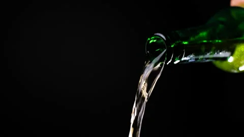 Stream of beer runs through the open green glass bottle in slow motion video Video stock 154193157