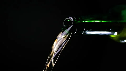 Stream of beer runs through the open green glass bottle. Stock Footage 154712939