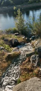 A stream cascading down into a lake Stock Photos