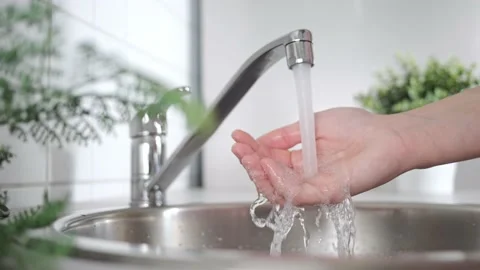 A stream of clean water drink flows into human hands. Wash hands and hygiene Stock Footage 197115723