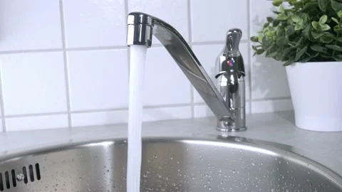 A stream of clean water drink flows from the kitchen faucet into the stainless Stock Footage 197115932