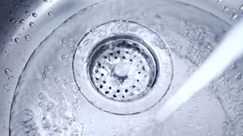 A stream of clean water drink flows from the kitchen faucet into the stainless Stock Footage 197115953