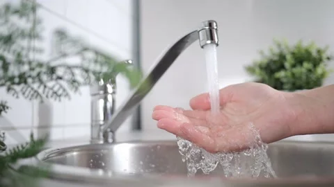 A stream of clean water drink flows into human hands. Wash hands and hygiene Stock Footage 202317646