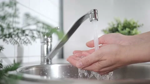 A stream of clean water drink flows into human hands. Wash hands and hygiene Stock Footage 210239487