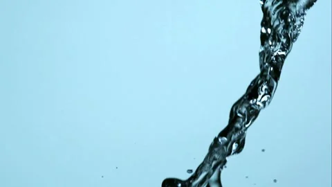 A stream of clean water pours vertically against a blue background. Stock Footage 326626390