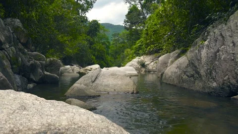 Stream clean water in river flowing between large stones and boulders. Green Stock Footage 93419020