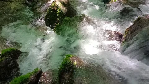 A stream of clear mountain water falling on moss-covered rocks. Stock Footage 297440866
