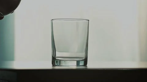 A stream of clear transparent cold water is poured into a glass Stock Footage 154822270