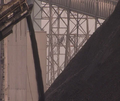 Stream of coal pouring onto coal heap; in front of scaffolding Stock Footage 86693957