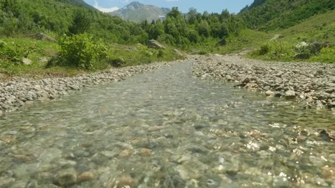 Stream with crystal clear water. Small rocks are on bed of stream Stock Footage 140094260