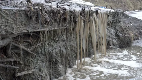 The stream of dirty, muddy water flows down from a stream a waterfall  Stock-Footage 104662943