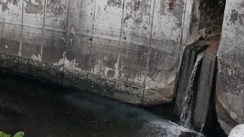 A stream discharging wastewater into a dirty river Stock Footage 292904043