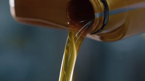 A stream of engine oil pouring from a canister during car maintenance Stock Footage 340581144
