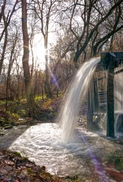 A stream of flowing clean spring water in an old mill. Photo taken in autumn  Stock Photos