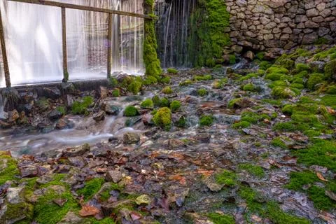 A stream of flowing clean spring water in an old mill. Photo taken in autumn  Foto stock