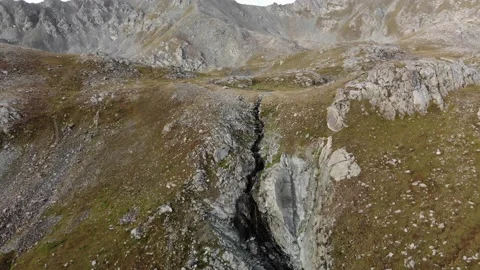 A stream flowing from a mountain lake cuts through solid rocks Stock Footage 151013770