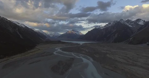 Stream flowing out of the lake surrounded with snow covered mountains Stock Footage 95016031