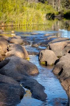 A stream flowing over and eroding a granite rock riverbed. Foto stock