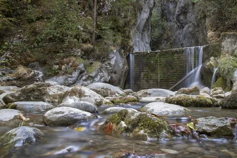 Stream flowing over large rocks with small waterfall Stock Photos