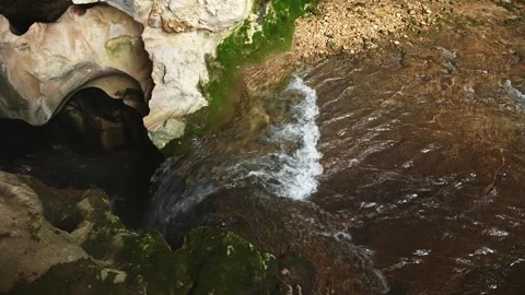 A stream of flowing river water, forming waterfall in the cave of water, overgro 스톡 동영상 271300264