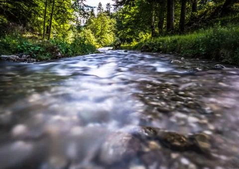 Stream flowing smoothly between rocks in the mountains. Stock Photos