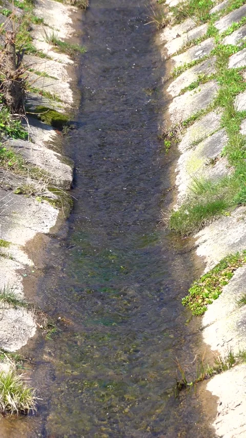 Stream flowing through a concrete chute into a lake Stock Footage 270171061