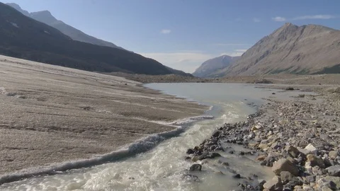 Stream flowing through landscape on a sunny day Stock Footage 99080431