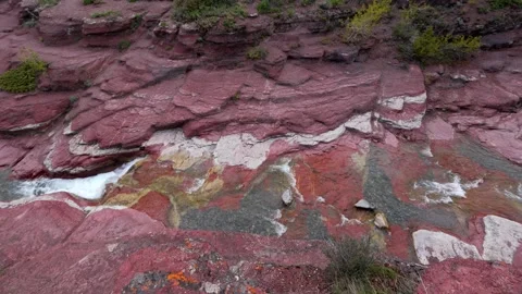 Stream flowing through layered red rock formations in Waterton Lakes National Stock Footage 330880009