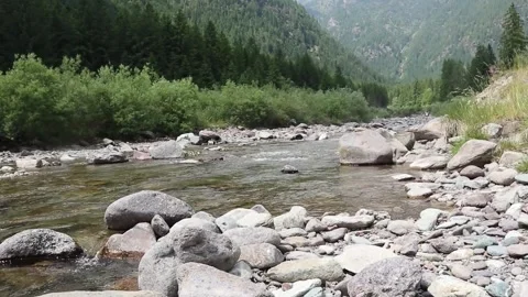 Stream flows between the mountains in uncontaminated natural environment Stock Footage 312275209