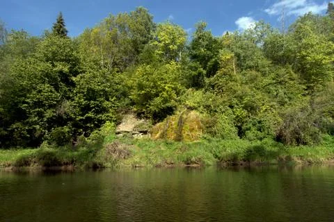 The stream flows into the river on a summer day. Foto stock