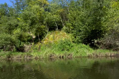 The stream flows into the river on a summer day. Foto stock