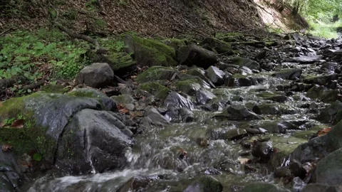 The stream flows on a stone of 4 k Stockbeeldmateriaal 138867677