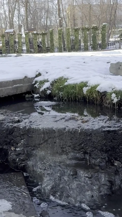 A Stream Flows Through a Snowy Ravine Stock Footage 302635582