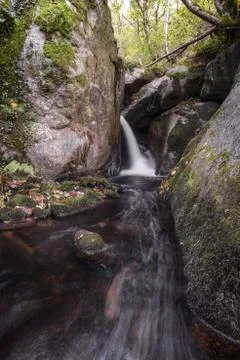 A stream forms a water jet between granitic rocks Foto stock