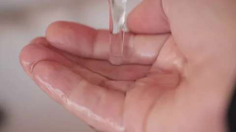 Stream of fresh drinking water pouring into human hand. Closeup and macro Stock Footage 168482912