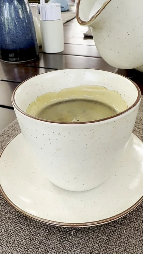 A stream of fresh milk is poured into a ceramic cup filled with aromatic bl.. Stock Footage 338020270