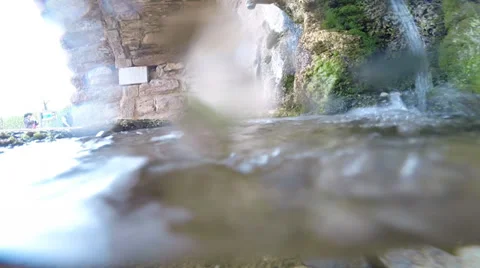 A stream of fresh water falls to the bottom of a pond Stock Footage 37501923