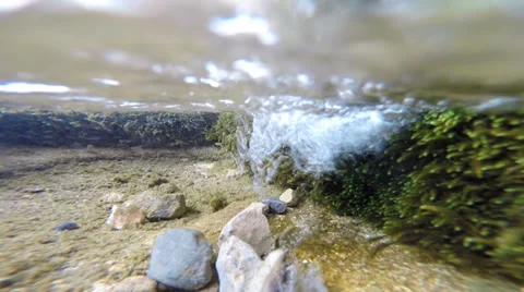 A stream of fresh water falls to the bottom of a pond Stock Footage 37503235