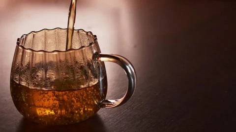Stream of freshly brewed tea filling glass mug, close up Stock Footage 345831695