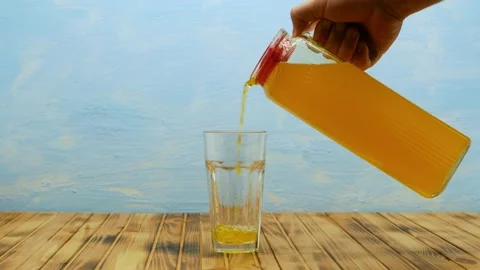 A stream of freshly squeezed natural orange juice poured into glass. Stock Footage 205713632