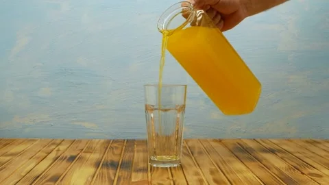 A stream of freshly squeezed natural orange juice poured into glass. Stock Footage 208899435