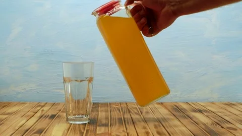 A stream of freshly squeezed natural orange juice poured into glass. Stock Footage 245753760