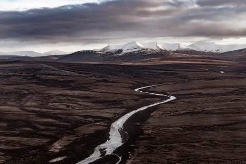 Stream going towards mountains under cloud cover Foto stock