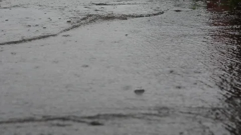 A stream of gray rainwater with traces of falling drops Видео 126004345