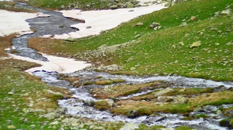 Stream in at green hill in High Snowy Mountains with Clouds. Kavkaz region Stock Footage 65762553