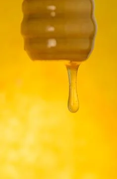 Stream of honey flows. Stream of pouring honey. Honey flowing from a wooden s Stock Photos