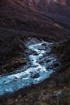 Stream with ice flowing down from the mountains Stock Photos
