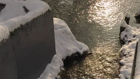 Stream joins the river. Snow. Video stock 88003522