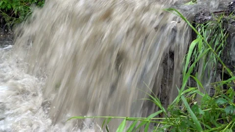 The stream of muddy water after a rain falls from height and flows down Video stock 111710016